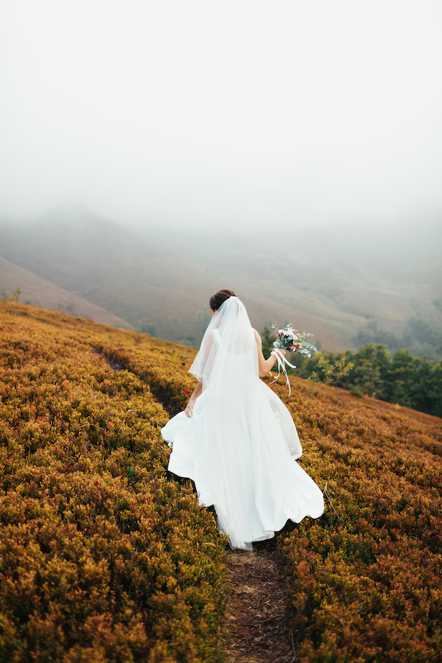 Beautifull wedding bride in foggy mountains